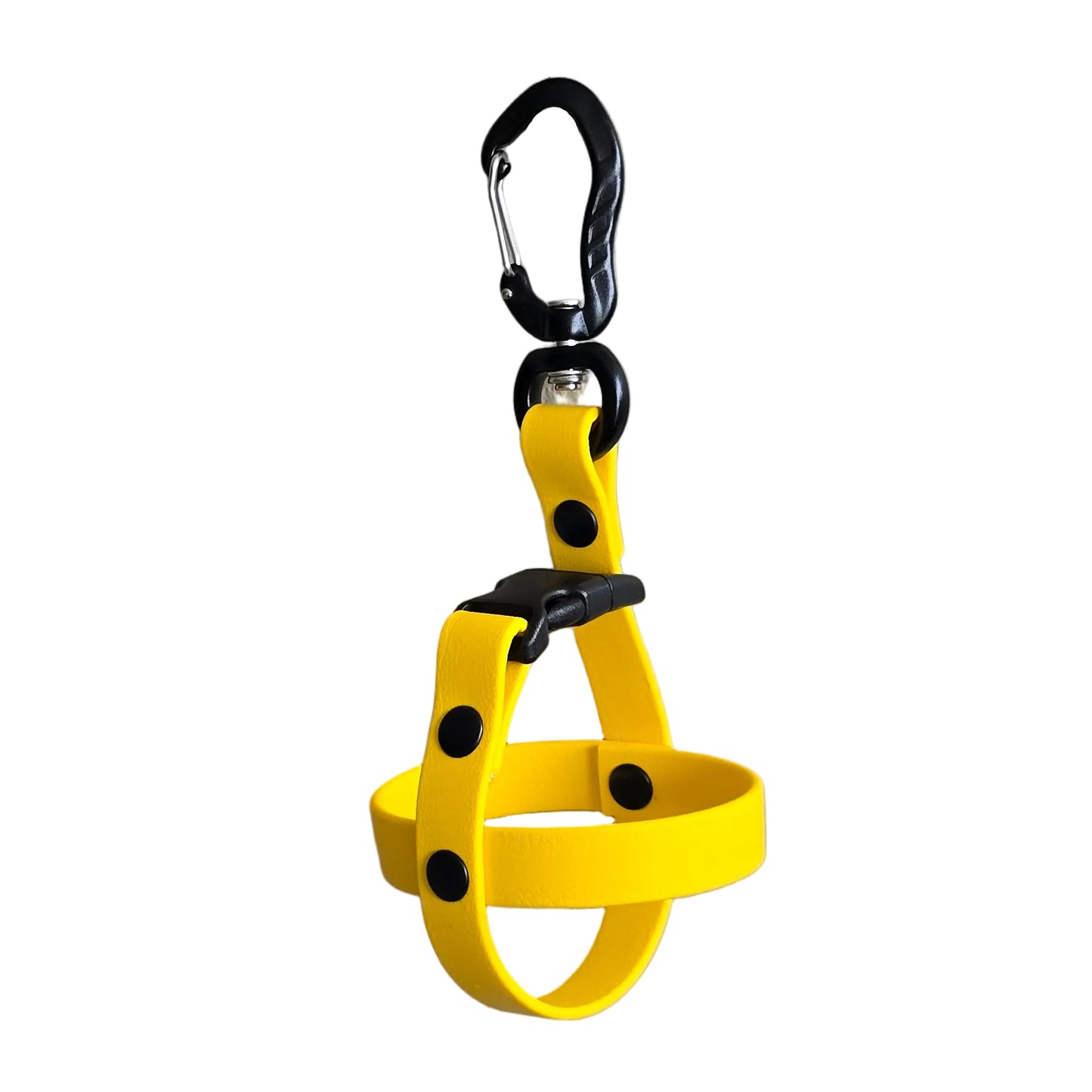 A clean studio photograph on a white background showing a single handcrafted yellow BioThane dog ball holder. The holder is formed by a crisscross BioThane strap secured by sturdy black rivets. At the top, a quick-release black buckle connects to a heavy-duty black aluminum carabiner with a swivel action and a screw-lock mechanism. The design illustrates a durable, easy-to-clean, and secure way to carry fetch balls hands-free. Note that no balls are included.