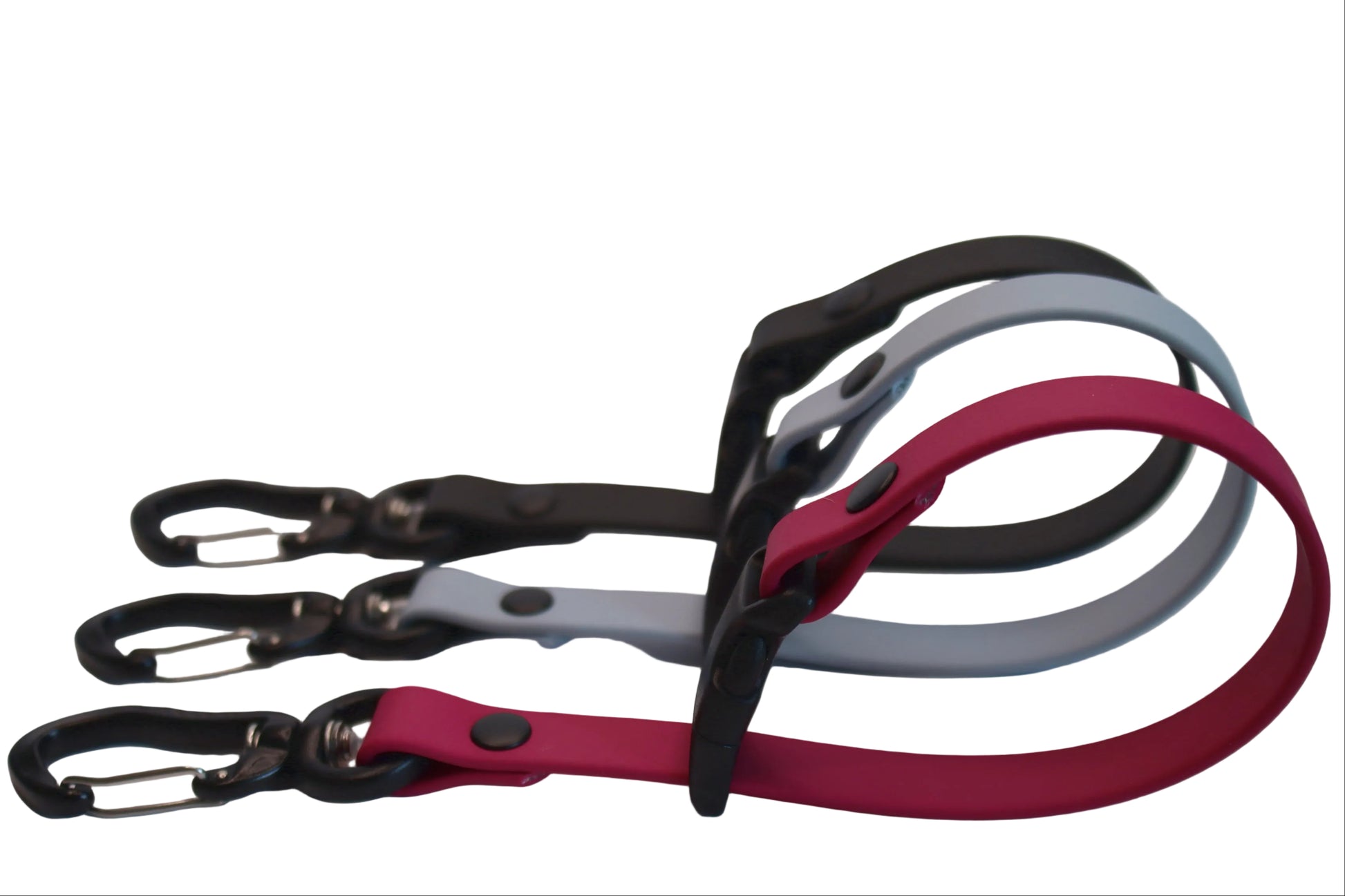 Side view of three BioThane Long Line Keepers in Magenta Pink, Husky Blue, and Black, showing the loop design and black carabiner clips used for organizing dog training leads.